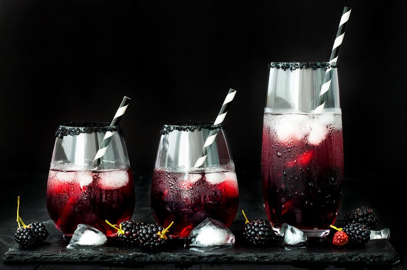 Blackberry drink in glasses with black sugar rim for fall and halloween parties