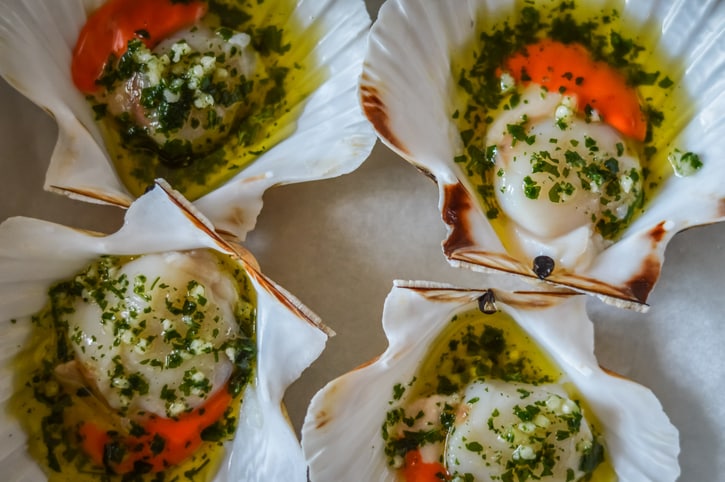 seasoned scallops with olive oil, garlic and parsley ready to be backed