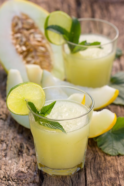 Melon smoothies with slices of melon on the wooden table