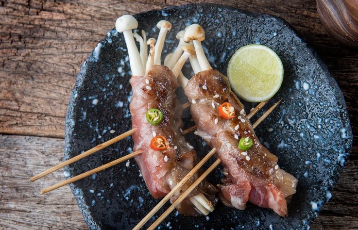 Slice beef roll with mashroom and spicy topping serve in Japanese style grilled.